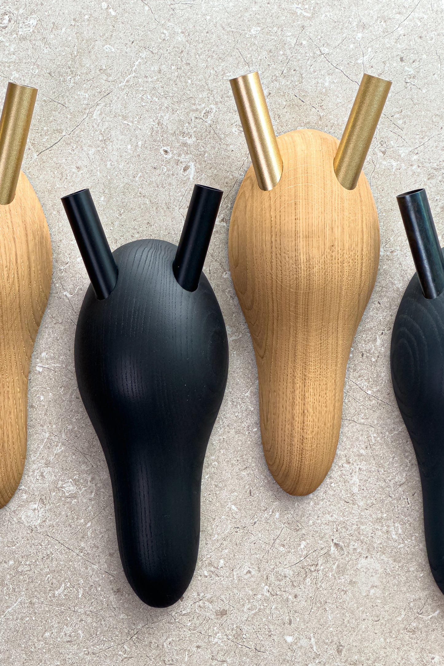 Gedrechselte Tierköpfe aus Holz in Geweihform. Die Hörner sind Röhrchen, die als Vase dienen. Es gibt die Varianten Esche schwarz gebeizt mit schwarzen Vasenröhrchen oder Eiche natur mit goldfarbenen Vasen.