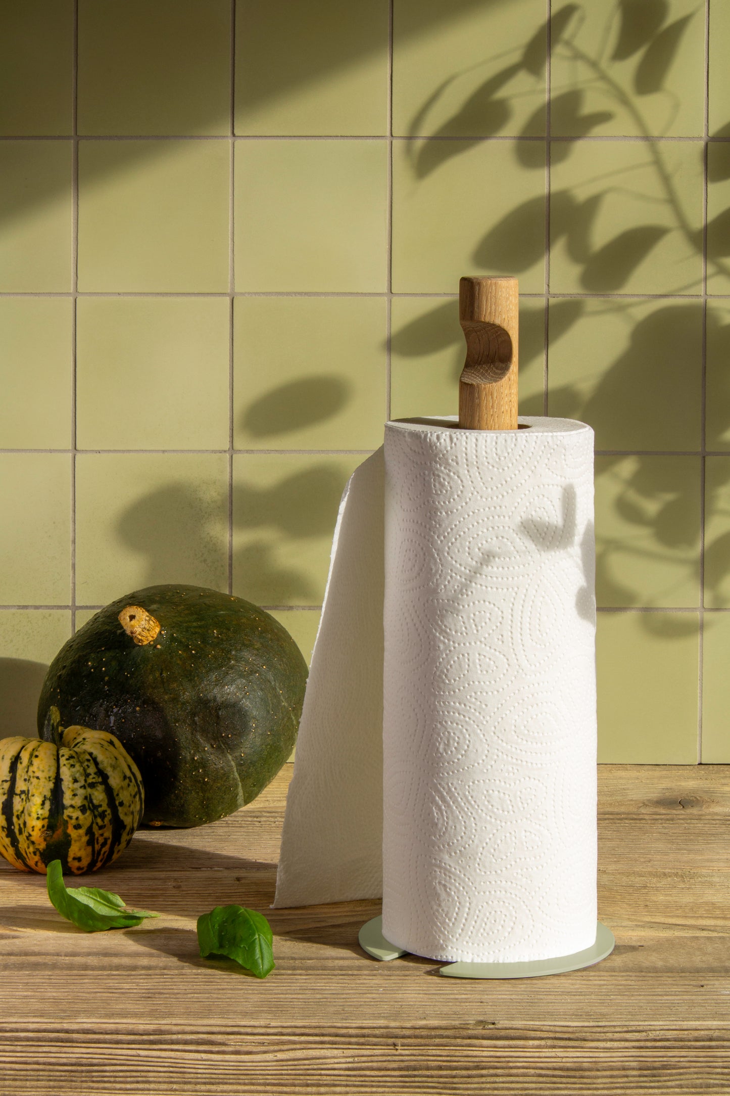 Standby Pistache: Dein Design Küchenpapierabroller, das besonderes Küchenaccessoire, hochwertig in Handarbeit produziert. Das besondere Design-Detail ist der runde Fußteller, der über eine gebogene Lasche mit dem massiven Rundstab aus geölter Eiche über zwei Holzdübel verbunden ist. Ein weiteres Highlight ist die Griffmulde fürs Handling