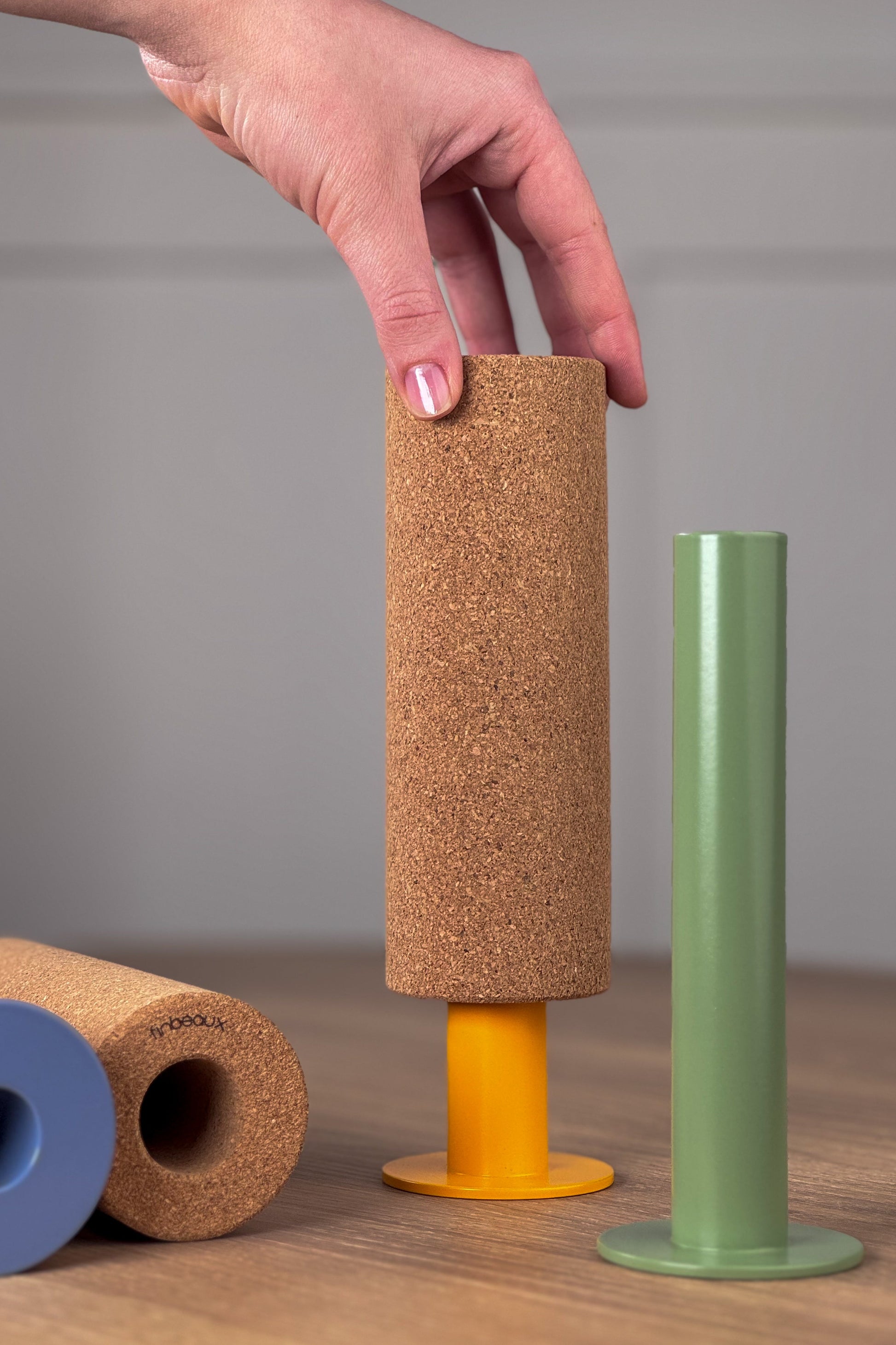 CELEBRATE modulares Deko- und Pinnobjekt aus Stahl und Kork beim Aufsetzen des Pinboard-Korkzylinders